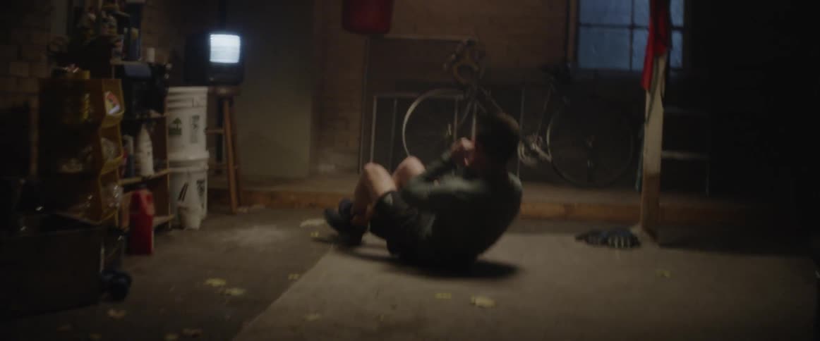 A man is doing sit ups in the dark room