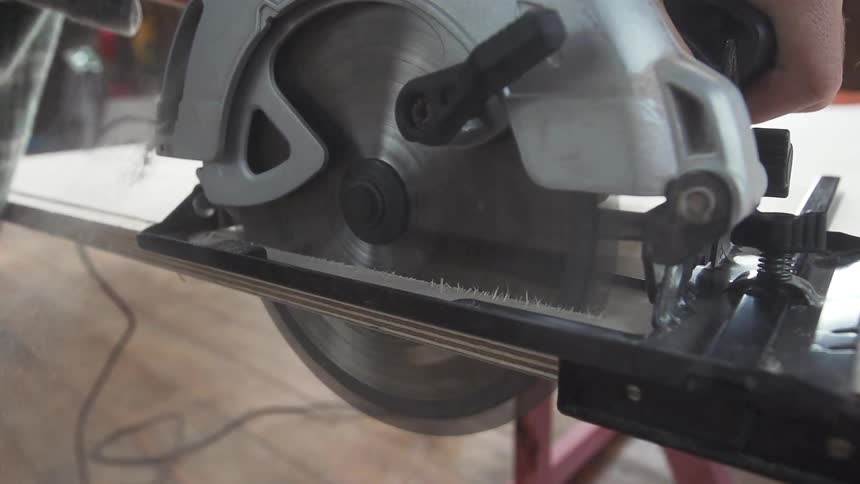 A saw is cutting wood