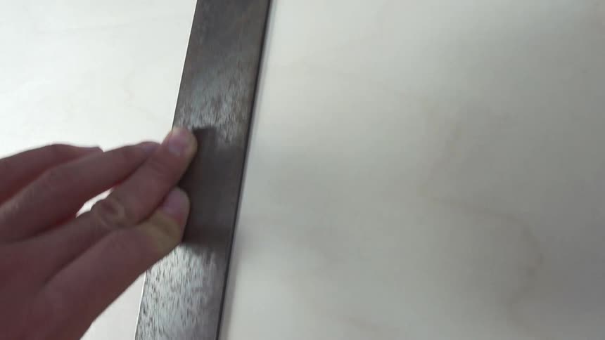 A person draws a line with a ruler