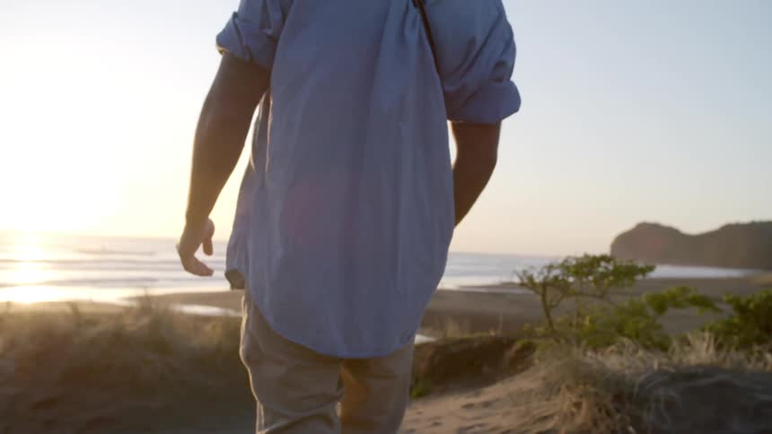A man is walking toward the beach