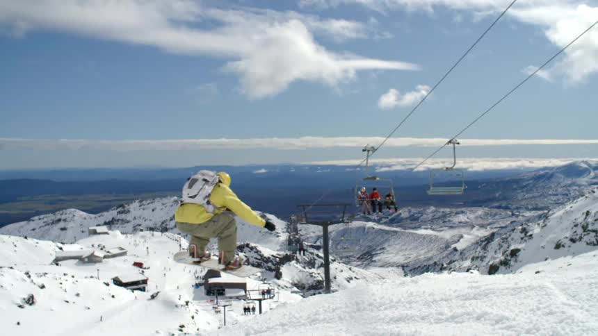A snowboarder races down the mountain
