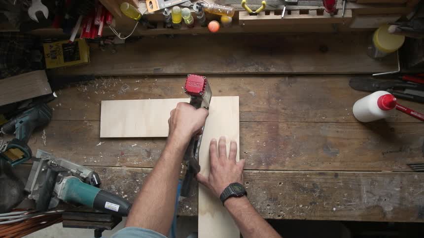Man using glue to attach two boards together
