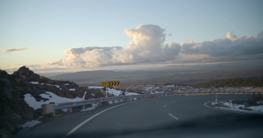 A vehicle drives on a rural road in the winter