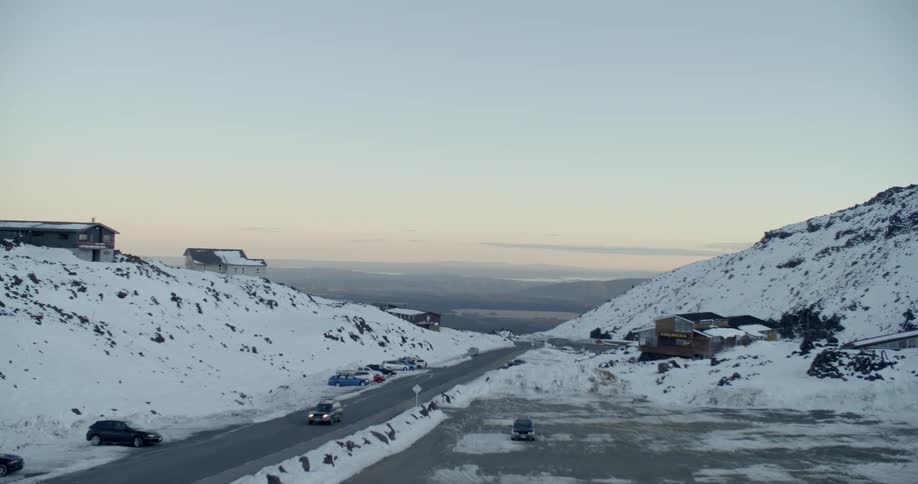 A road runs through snowy mountains
