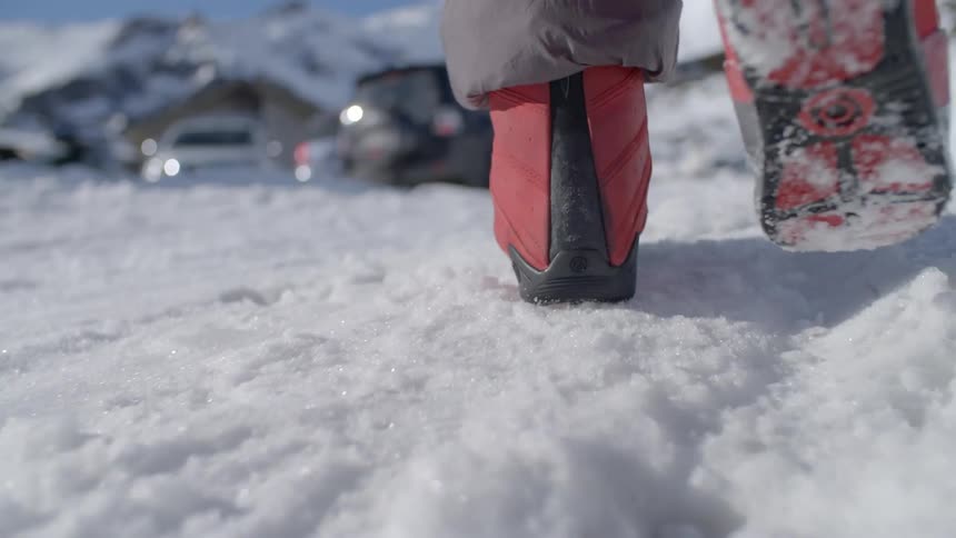 A woman walks across the snow