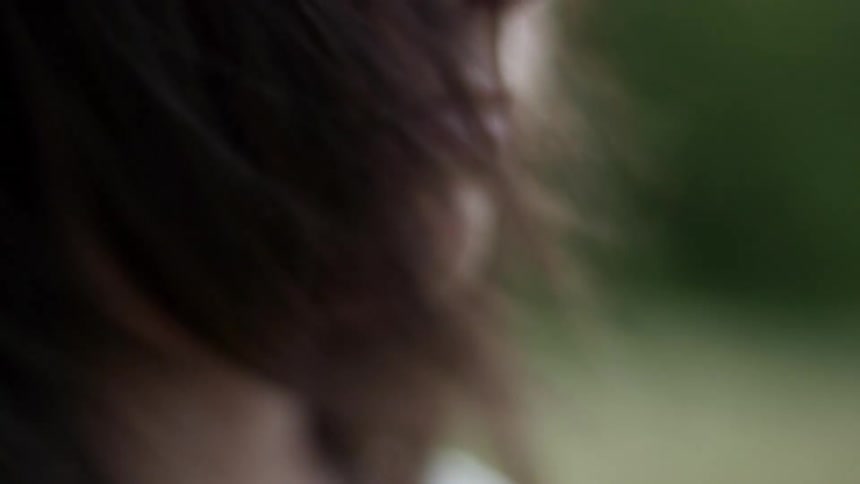 A woman is standing outside on a windy day
