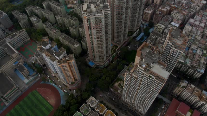There is a field near the tall buildings of the city