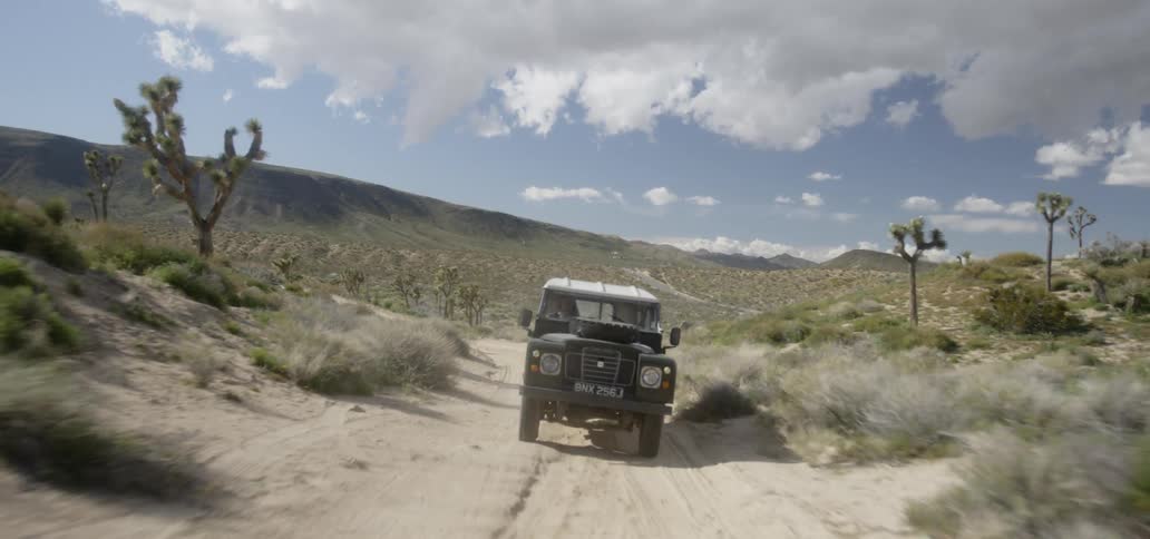 A vehicle drives across a desert