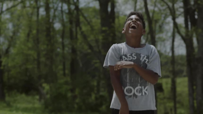 A boy throws the ball around in the park