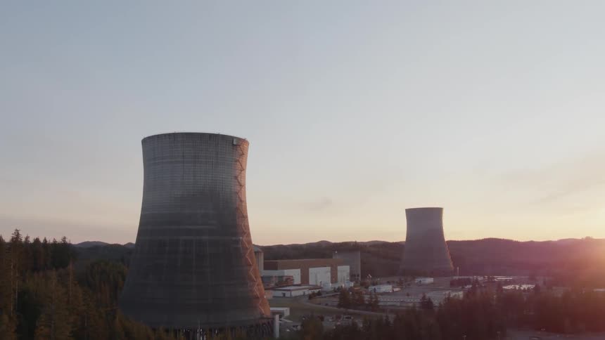 The sun starts to set behind a nuclear power facility