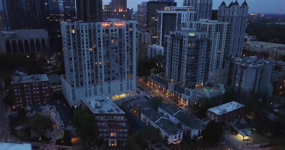 Lights are illuminating windows and streets in a city at dusk