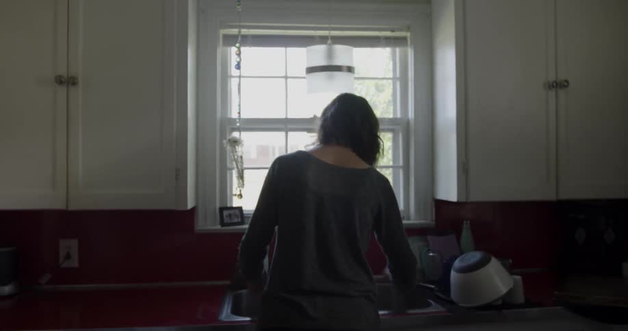 A woman washes dishes in a kitchen