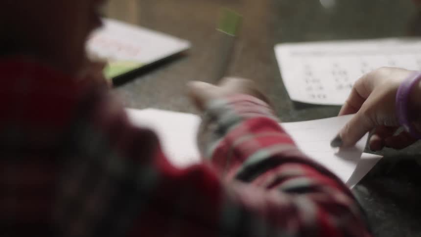 A child is writing on some papers