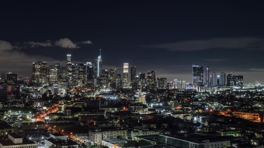 Clouds are drifting over a busy metropolis during the night