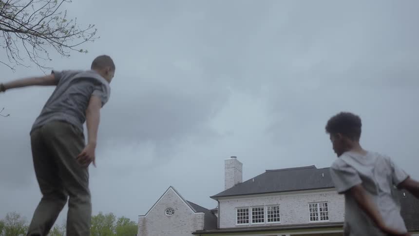 Two boys jumping on a trampoline