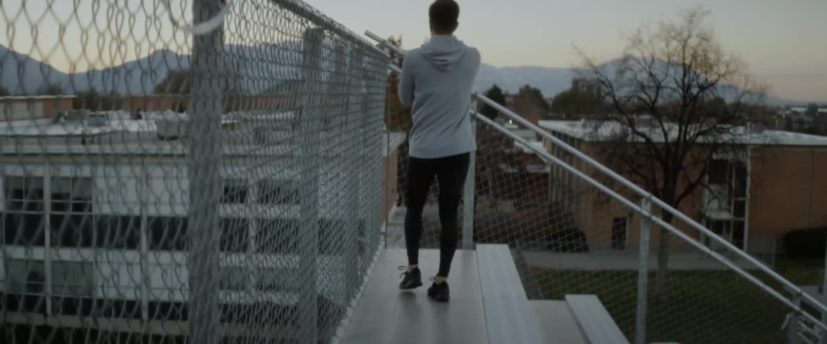 Man stretches on outdoor bleachers