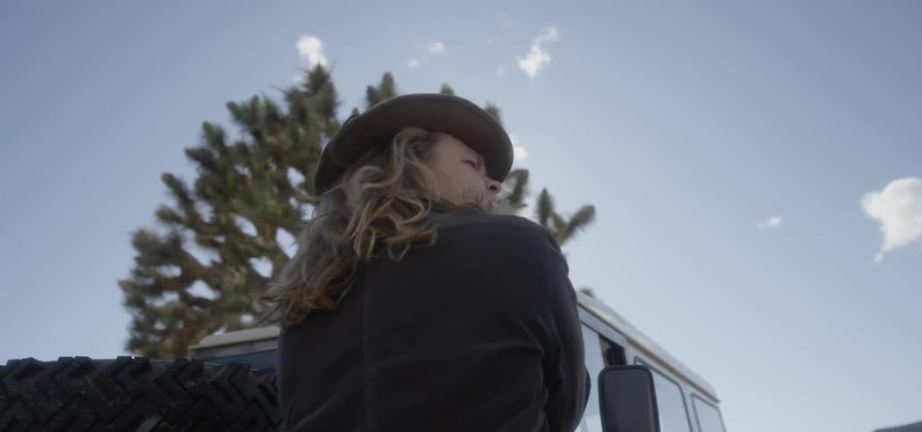 A man looks over to his side by the vehicle