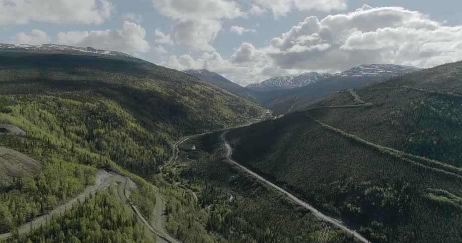 Highway twisting around green mountains on cloudy day
