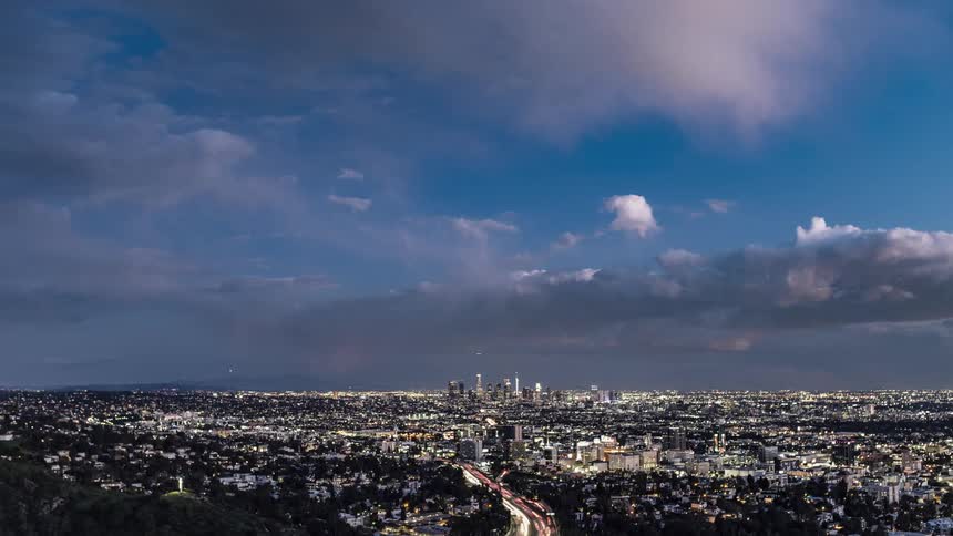 Time lapse of clouds moving over a busy city