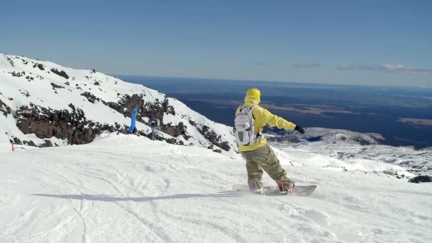 Man skiing down a snowy cliff on a sunny day