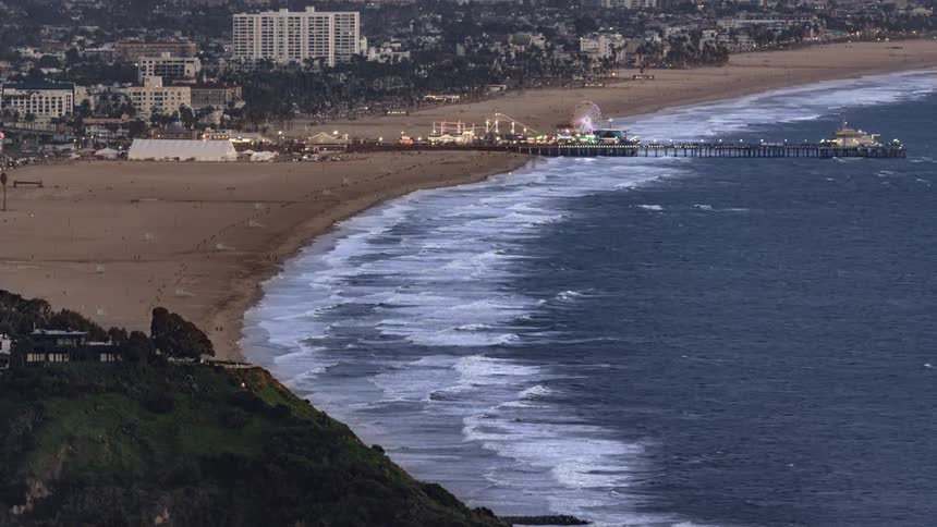 The pier on the beach has a ferris wheel