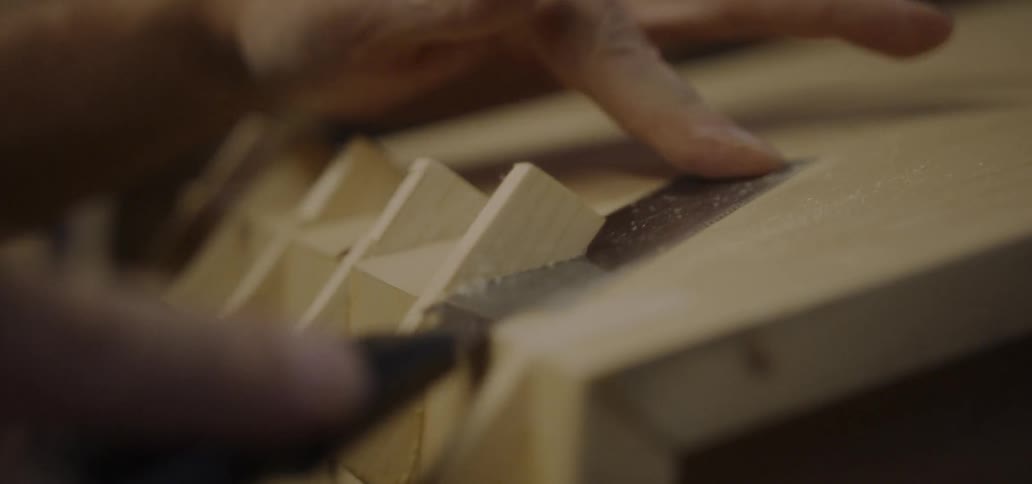 A carpenter saws a piece of wood