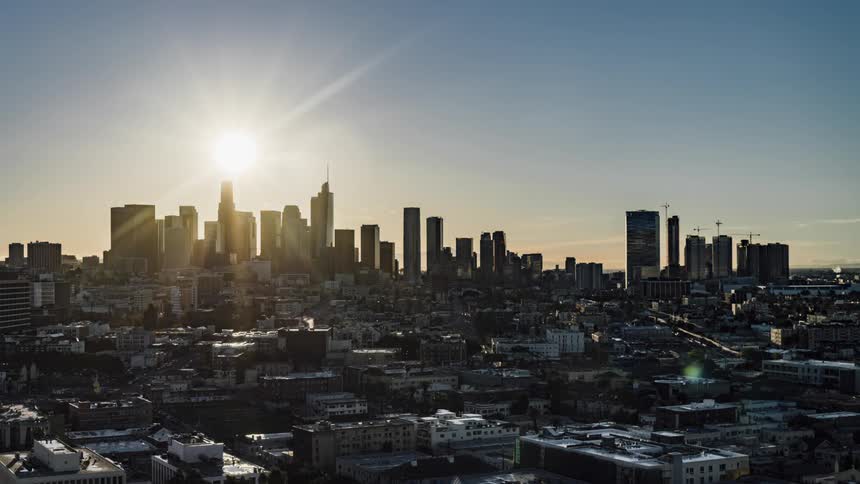 Night turns into a sunny day over a city skyline