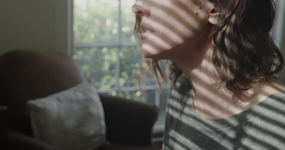 A woman is inside a living room singing during the day