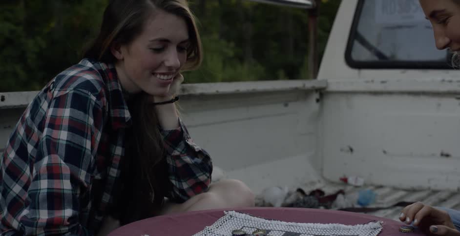 Two women play checkers in the back of a truck