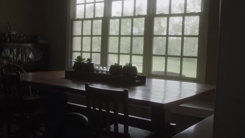 A dining room table sits next to a window