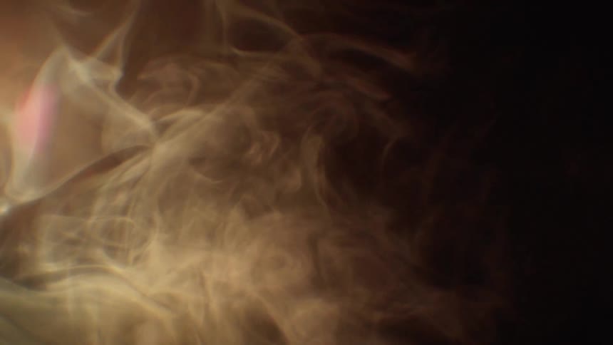 Light shines through smoke swirls