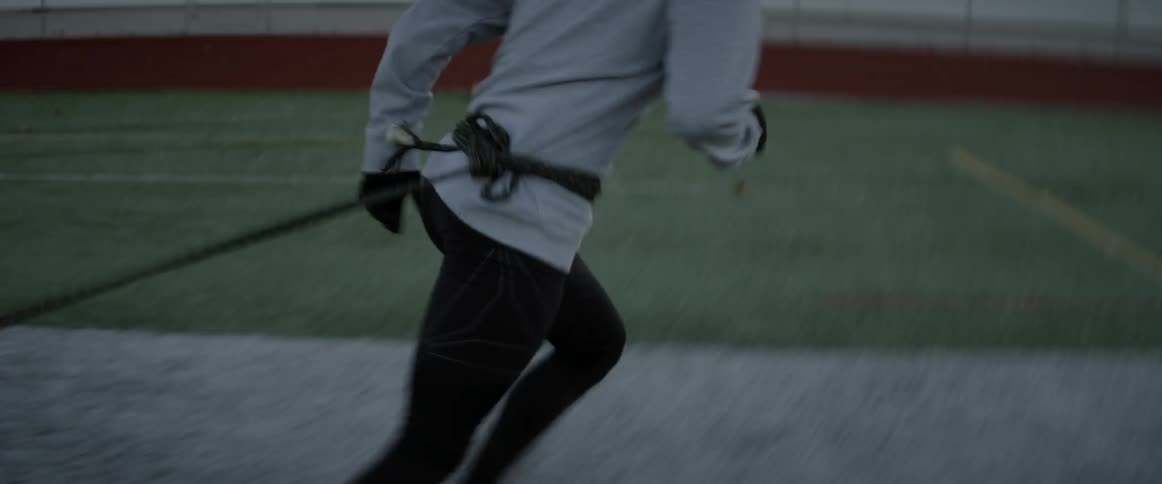 A man exercises on a football field