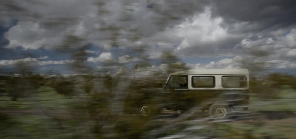 Person driving jeep through wilderness on cloudy day