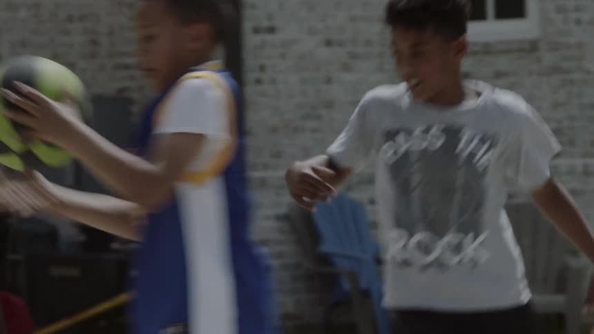 Boys play basketball on a home court
