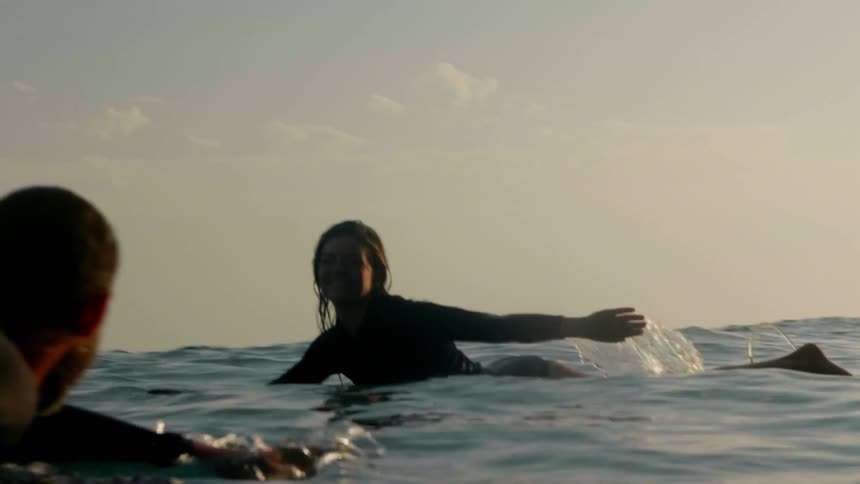 A surfer paddles out into the water