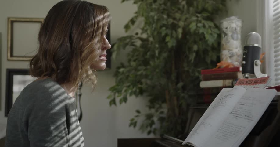 A woman sings and plays piano