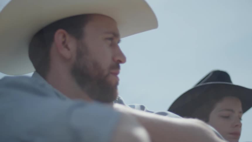 A man and boy wearing cowboy hats talk