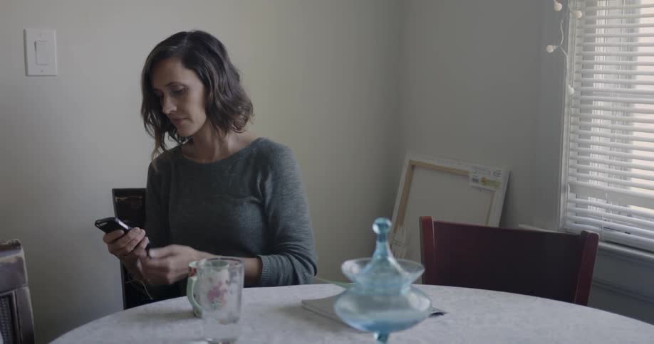A woman is checking her phone at the table