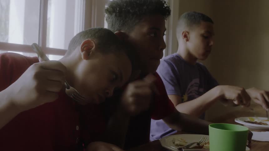 Boys eat at a dining room table