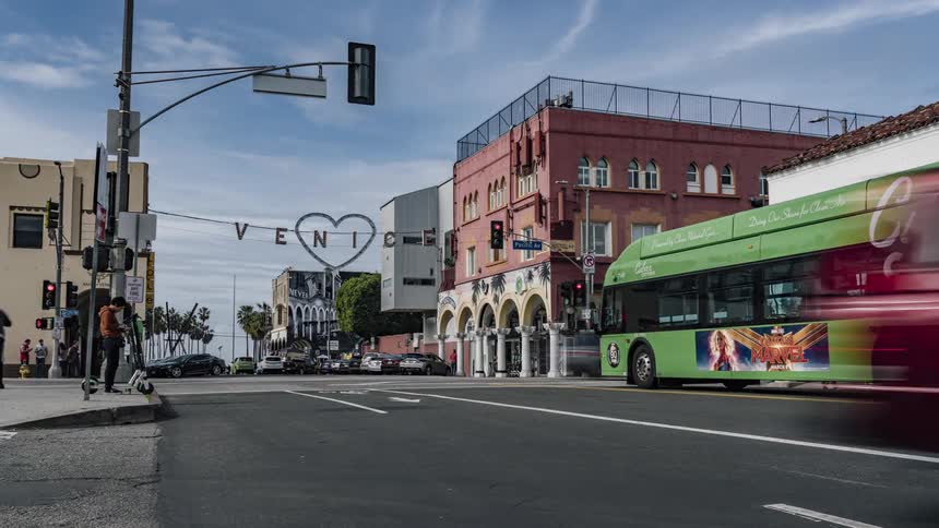 People drive and walk through the intersection in town