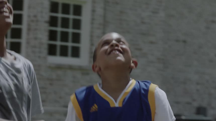 Boys play basketball on a home court