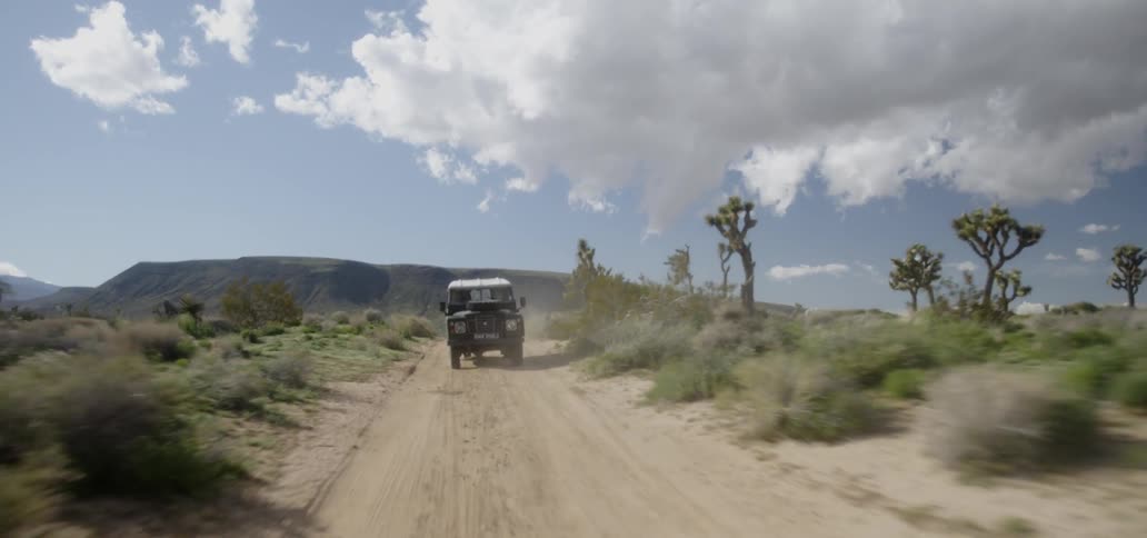 A truck travels on a desert dirt road