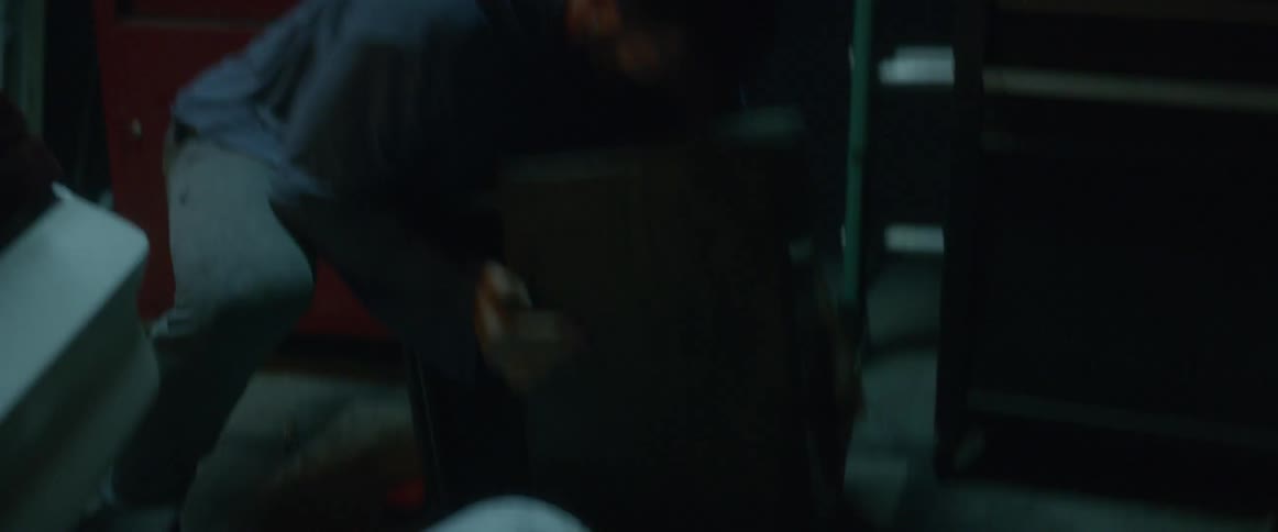 A man throws things around and slams draws