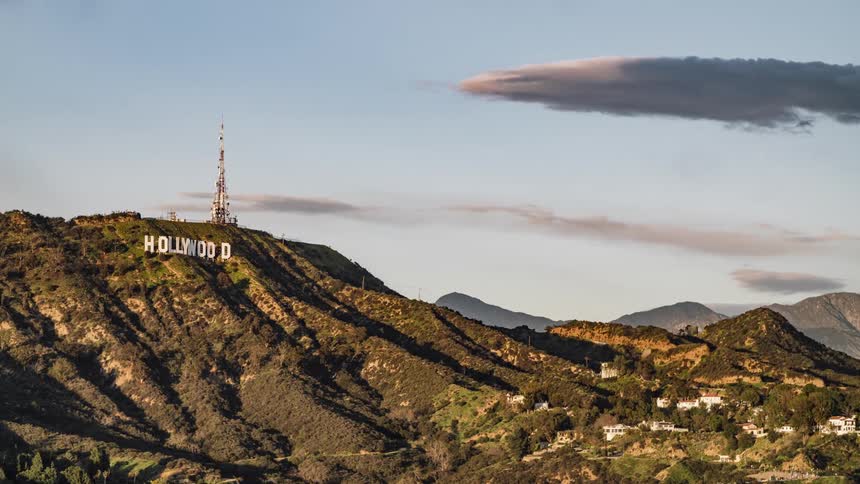 Clouds are drifting through the sky over the hollywood sign during the day