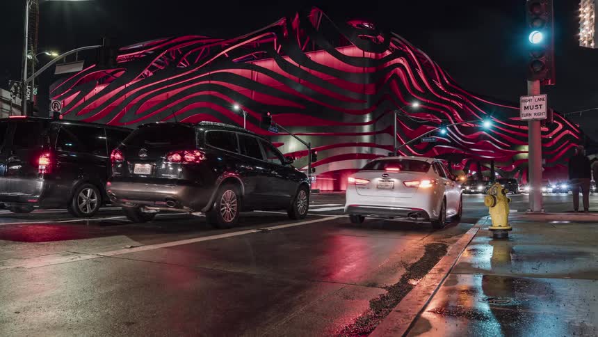Cars drive on a city street at night
