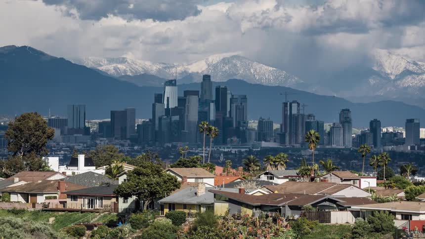 The tall buildings are near the mountain range