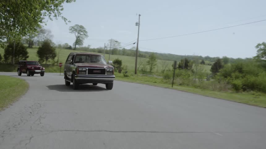 Vehicles drive on a rural road