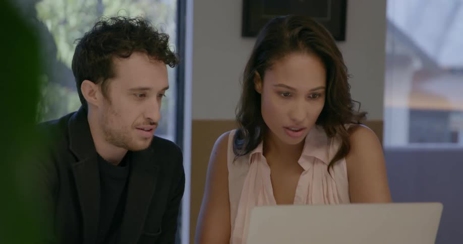Woman and man talk as they look at a laptop