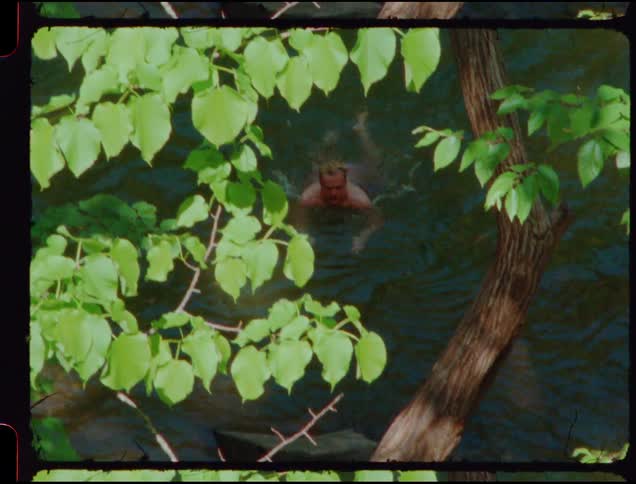A man swims towards the river shore