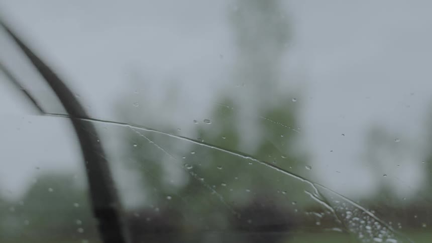 The rain slowly covers the windshield